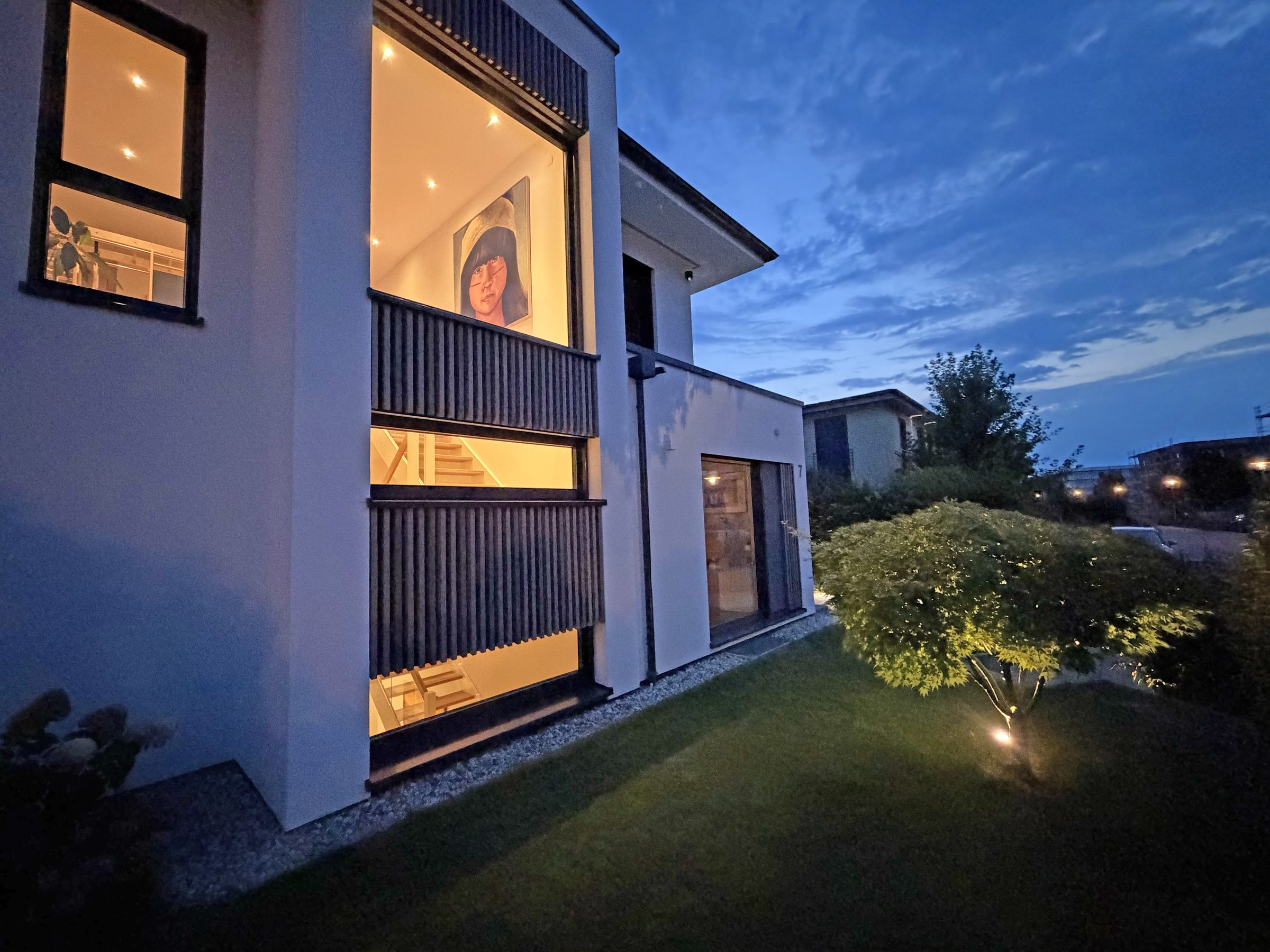 Haus bei Dämmerung mit beleuchteten Fenstern